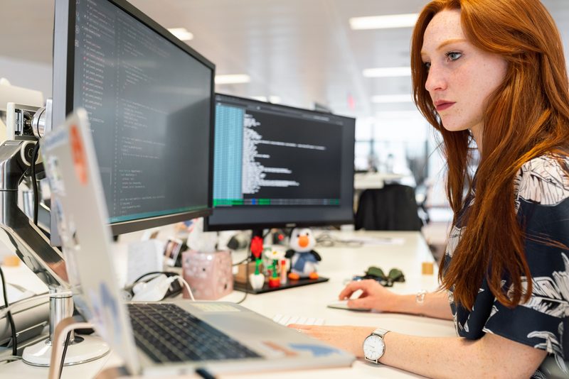 Diseñador trabajando una interfaz en un monitor grande.