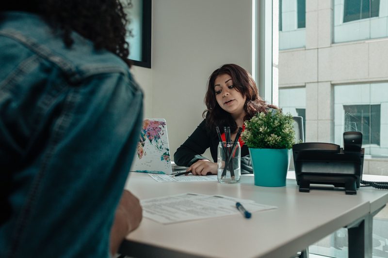 Consultora explicando el proceso a un cliente en su despacho.